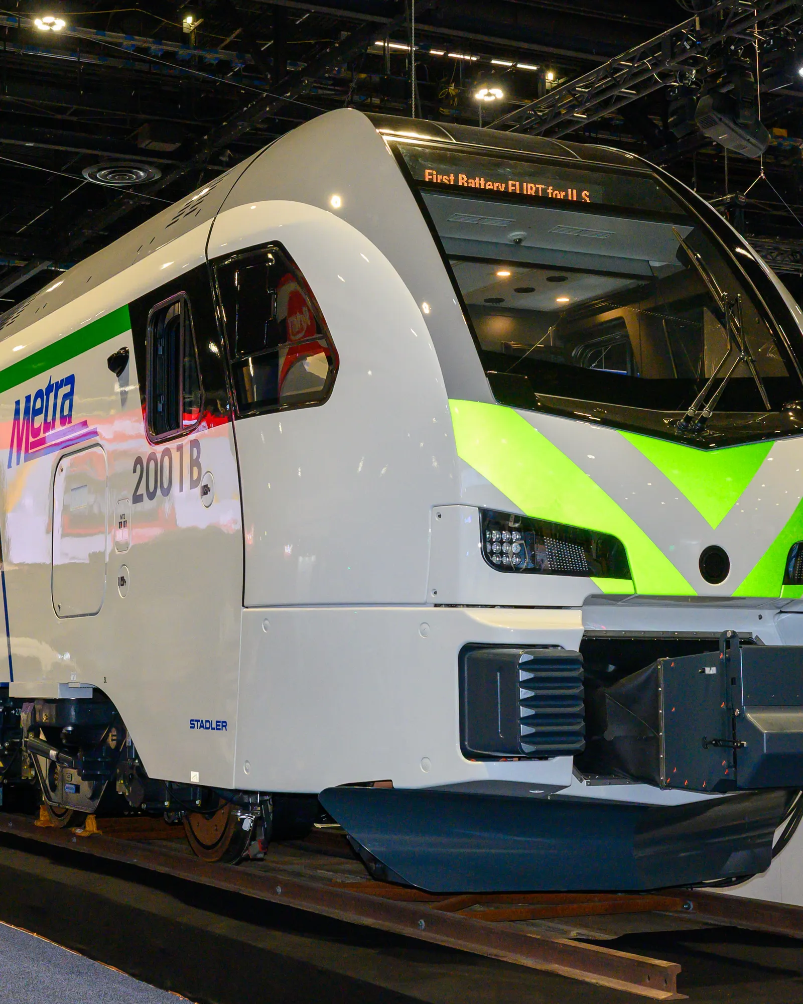 Front of a white passenger rail vehicle lettered "Metra."