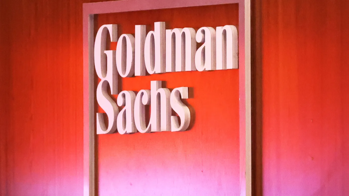 image of Goldman Sachs logo on wall with red background.