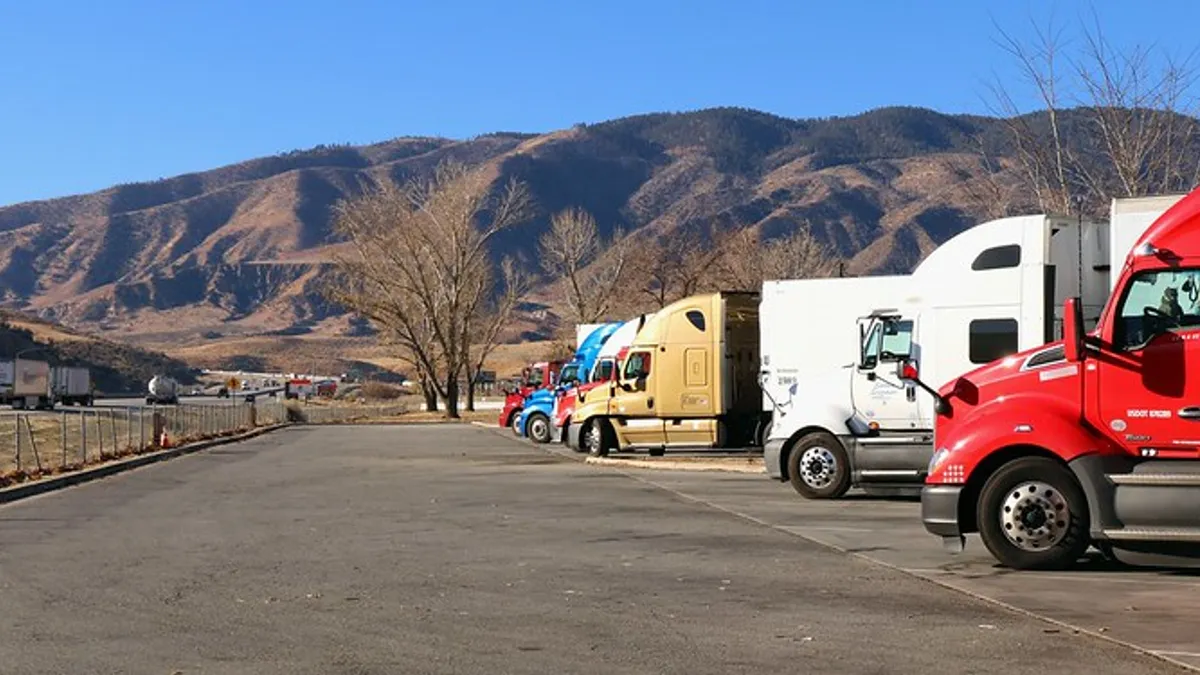 Trucks rest parked on the side of a highway.