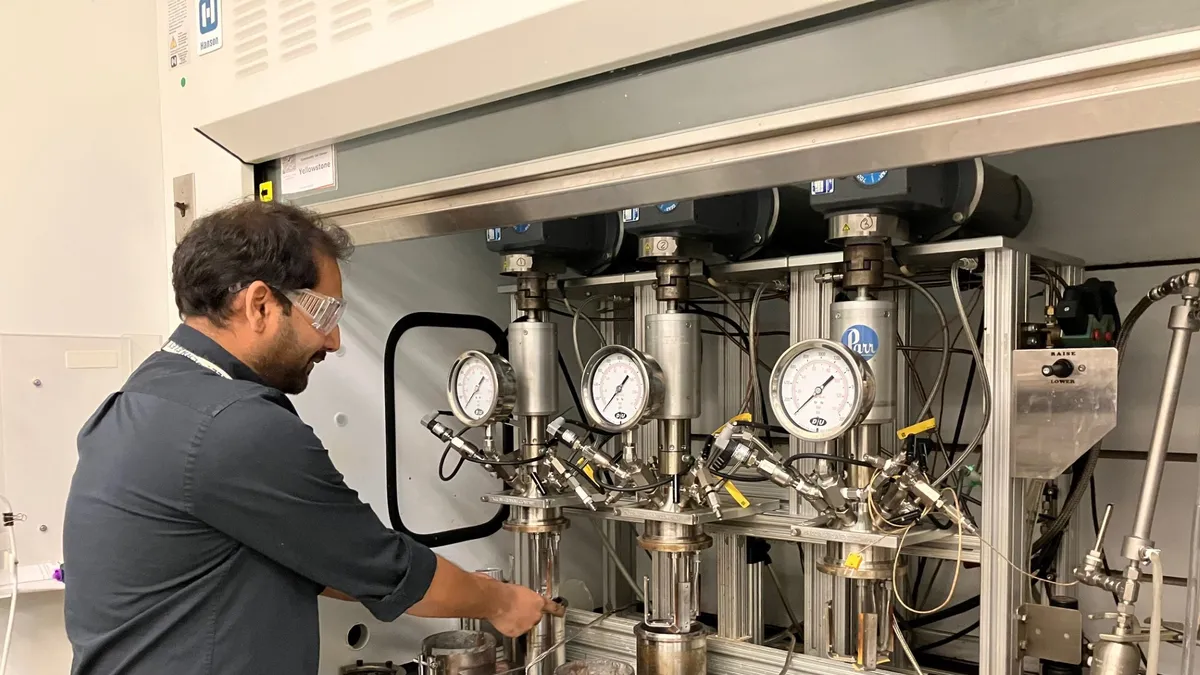 A person from the Berkeley National Laboratory demonstrates plastic recycling research