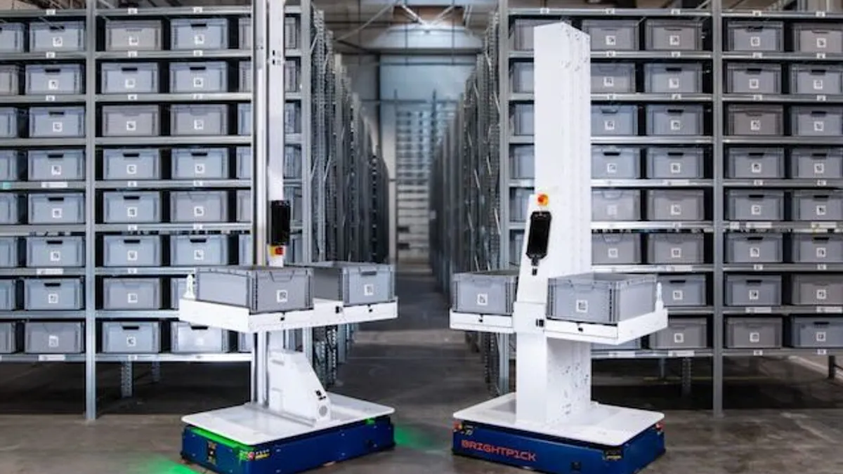 Brightpick robots standing in front of metal racks in a facility.