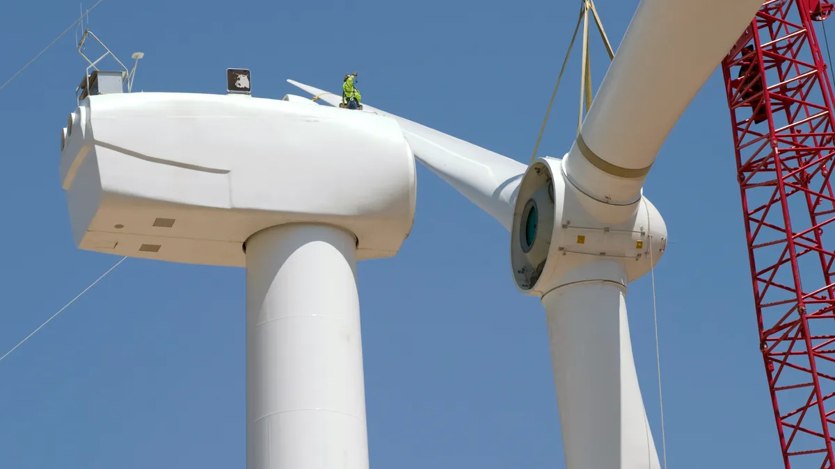 Workers assemble a wind turbine.