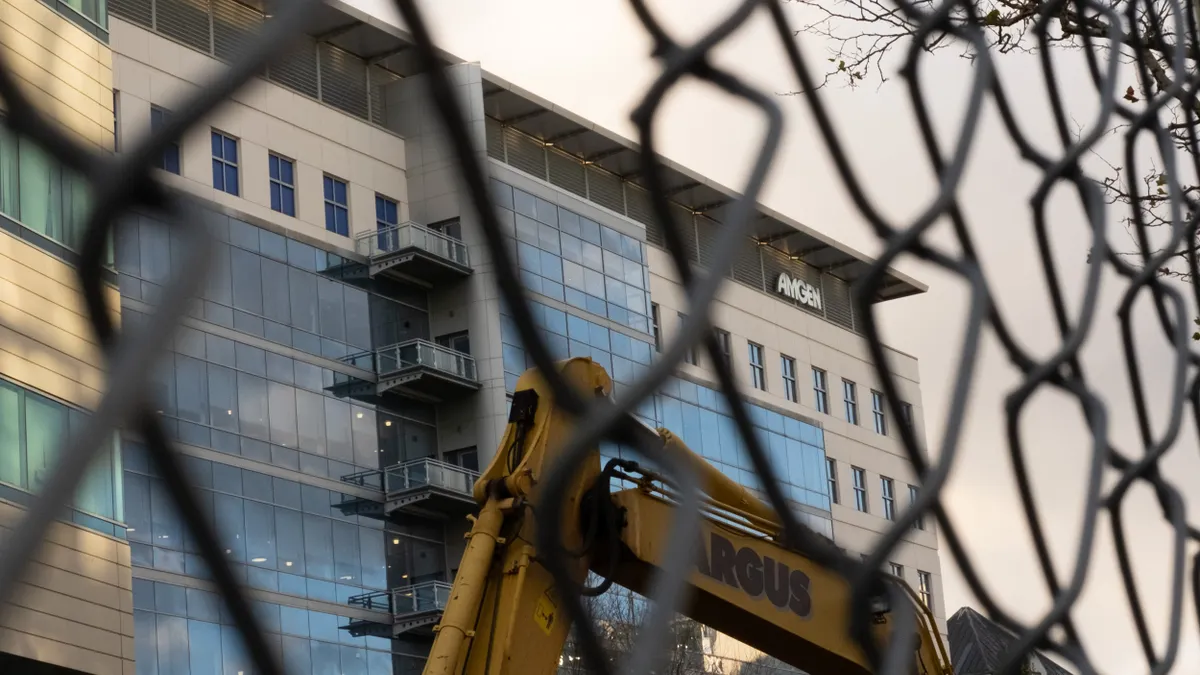 A building is seen through a fence.