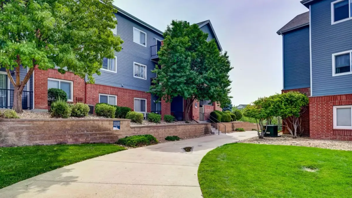 Paved walkway and grass between two apartment buildings