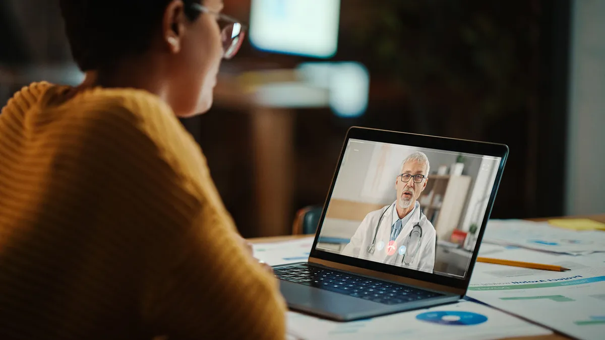 A patient on a video call with their doctor at home