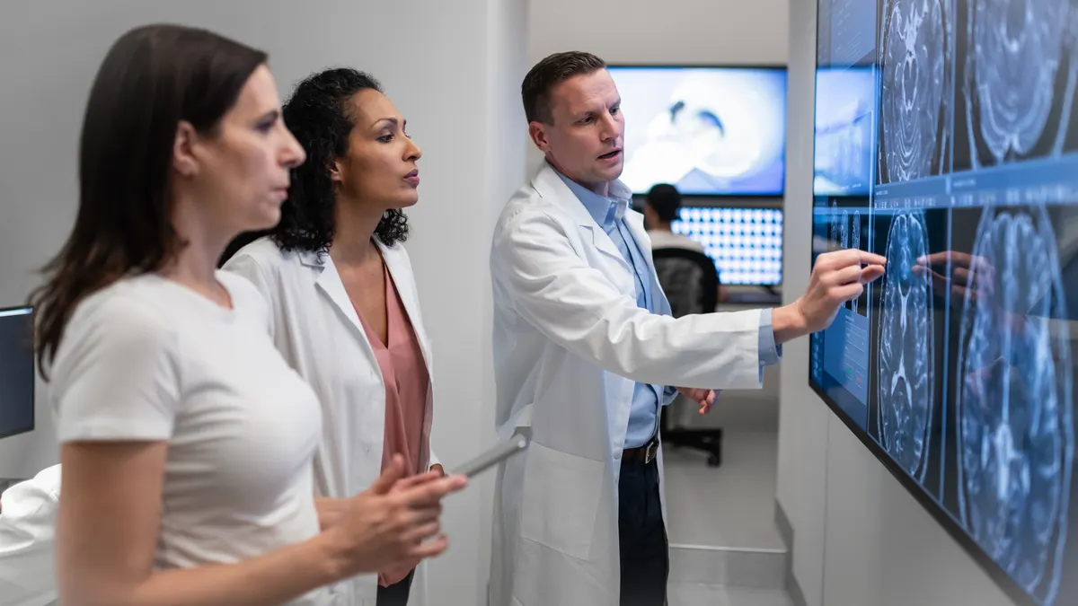 Small group of doctors consult over an MRI scan.