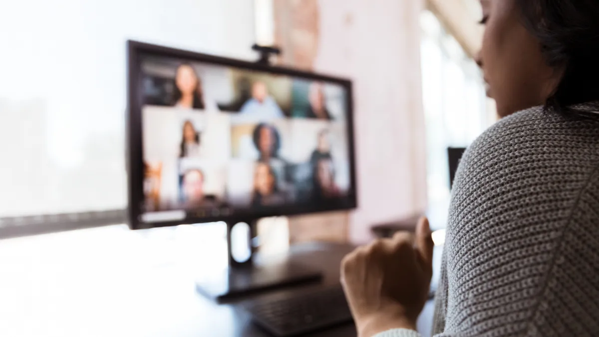 An employee presents to co-workers from her home office during a video call.