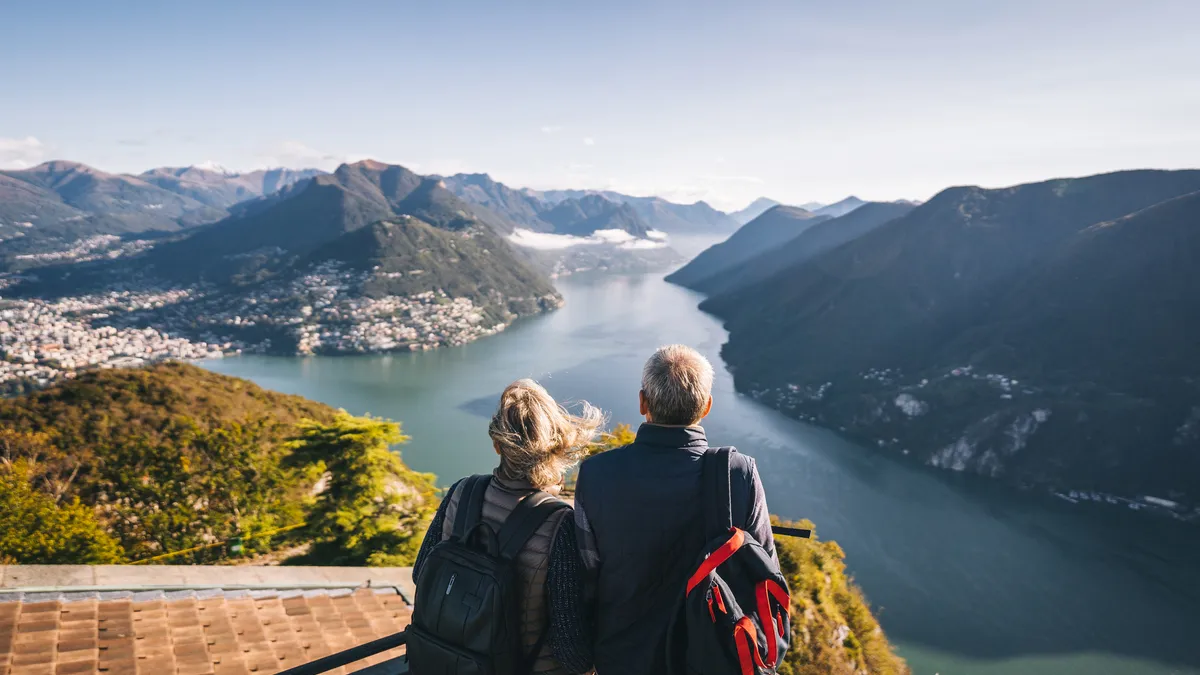 An older couple overlooks a lake from a great height.