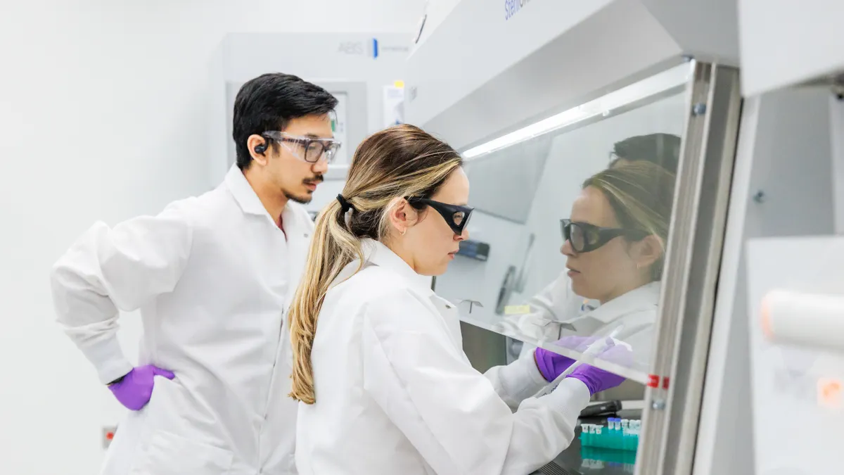 Two people in white lab coats work in Braskem's Renewable Innovation Center in Lexington, Massachusetts