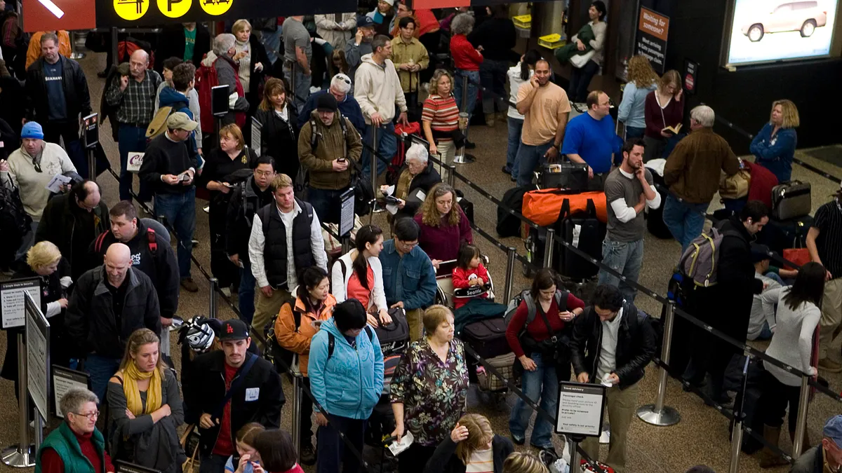 Travelers wait in line at the Seattle-Tacoma International Airport.