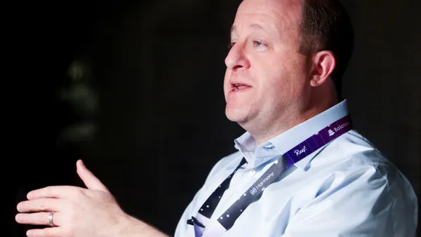 Colorado governor Jared Polis talks on a podcast.