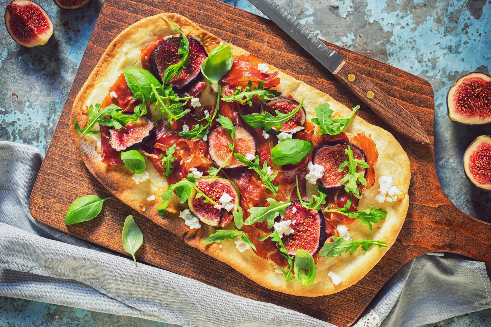 A photo of flatbread pizza on a cutting board.