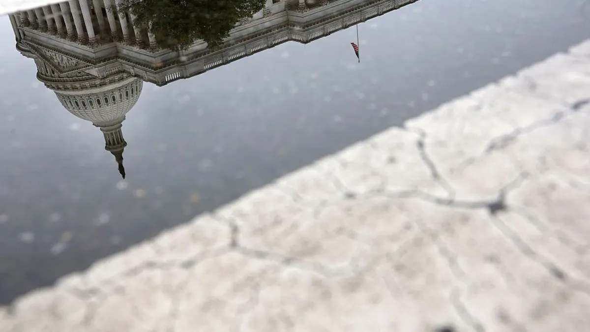 The US Capitol is reflected upside down in a cracked Washington, D.C. road