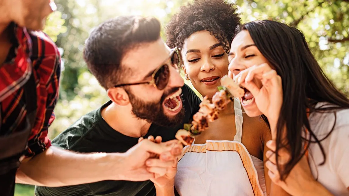 Friends eating skewers at an outdoor cookout