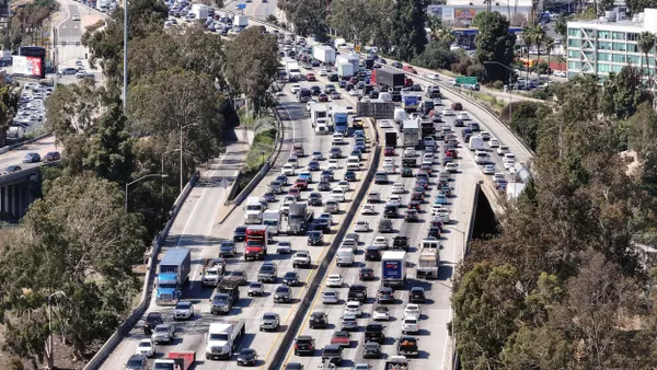 Aerial view of bumperto bumper traffic on an 8-lane freeway.
