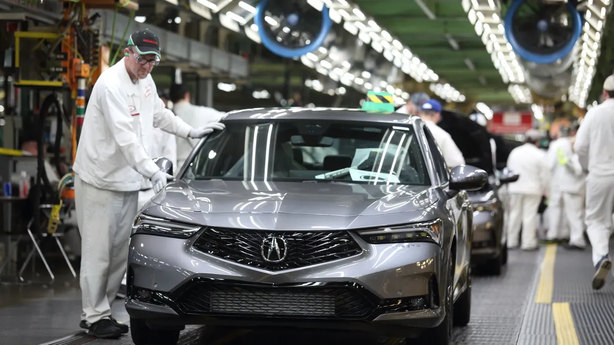 A worker inspects a 2023 Acura Integra as comes off of the assembly line at Honda's Marysville Auto Plant.