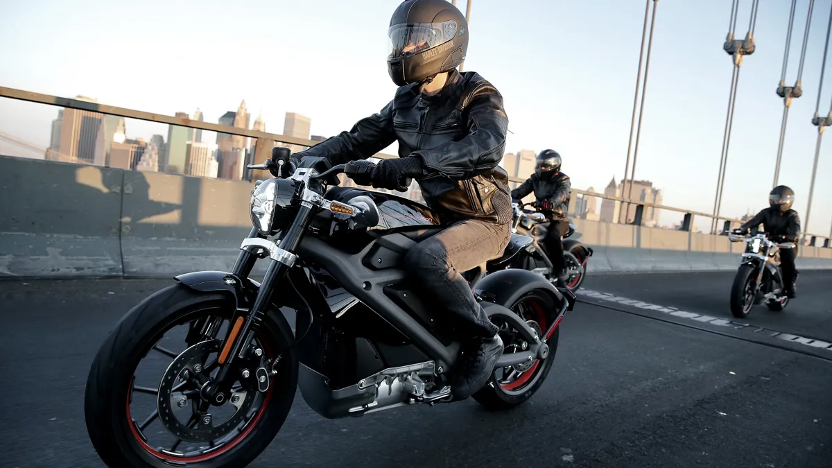 Image of motorcyclists driving over bridge.