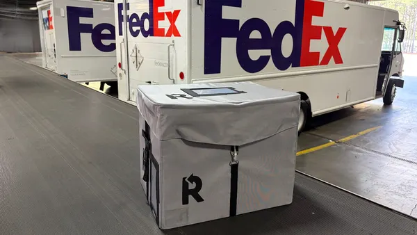 A Returnity box with FedEx trucks in the background