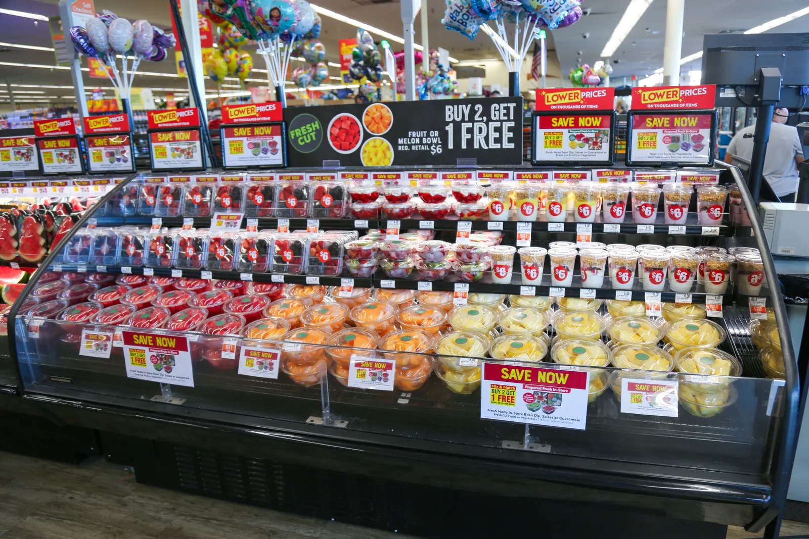 Fresh cut produce and yogurt parfaits on display in a grocery store