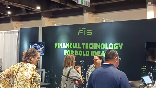 People standing at a booth in front of a conference booth with a placard that says 'FIS.'