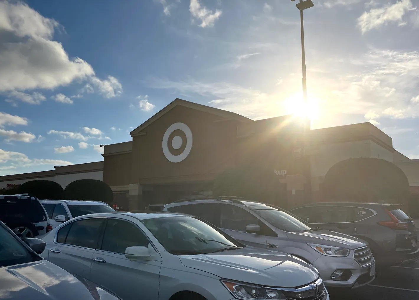 Target's bullseye logo on a storefront with cars in the parking lot