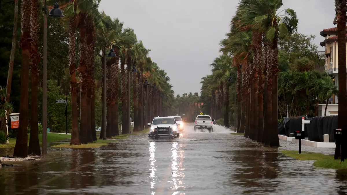 Vehicles drive along a flooded street as Hurricane Helene churns offshore on September 26, 2024 in St. Pete Beach, Florida.