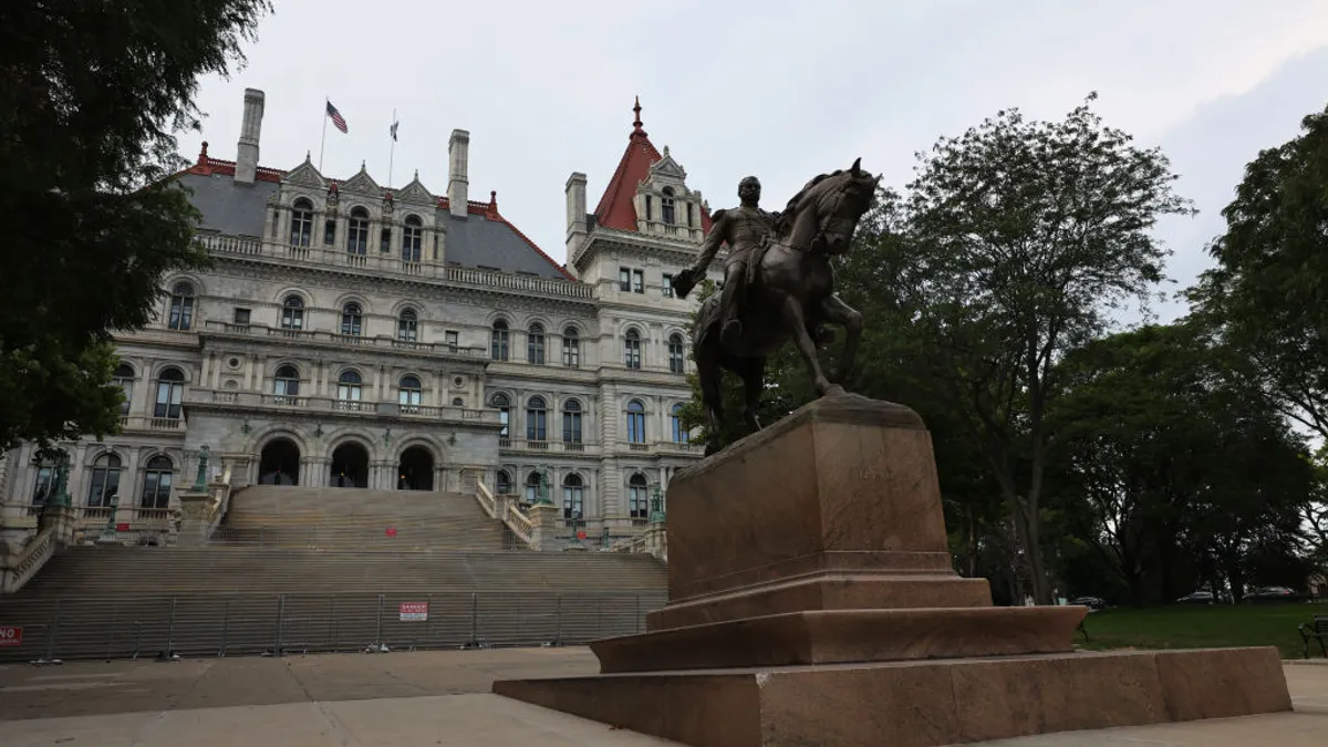 A view of the outside of the New York State Capitol building on an overcast day.