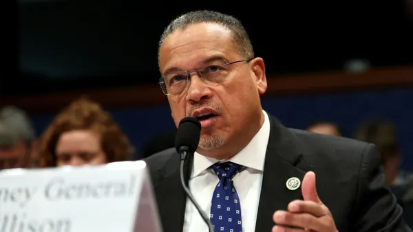 Minnesota Attorney General Keith Ellison speaks into a microphone while testifying before Congress.