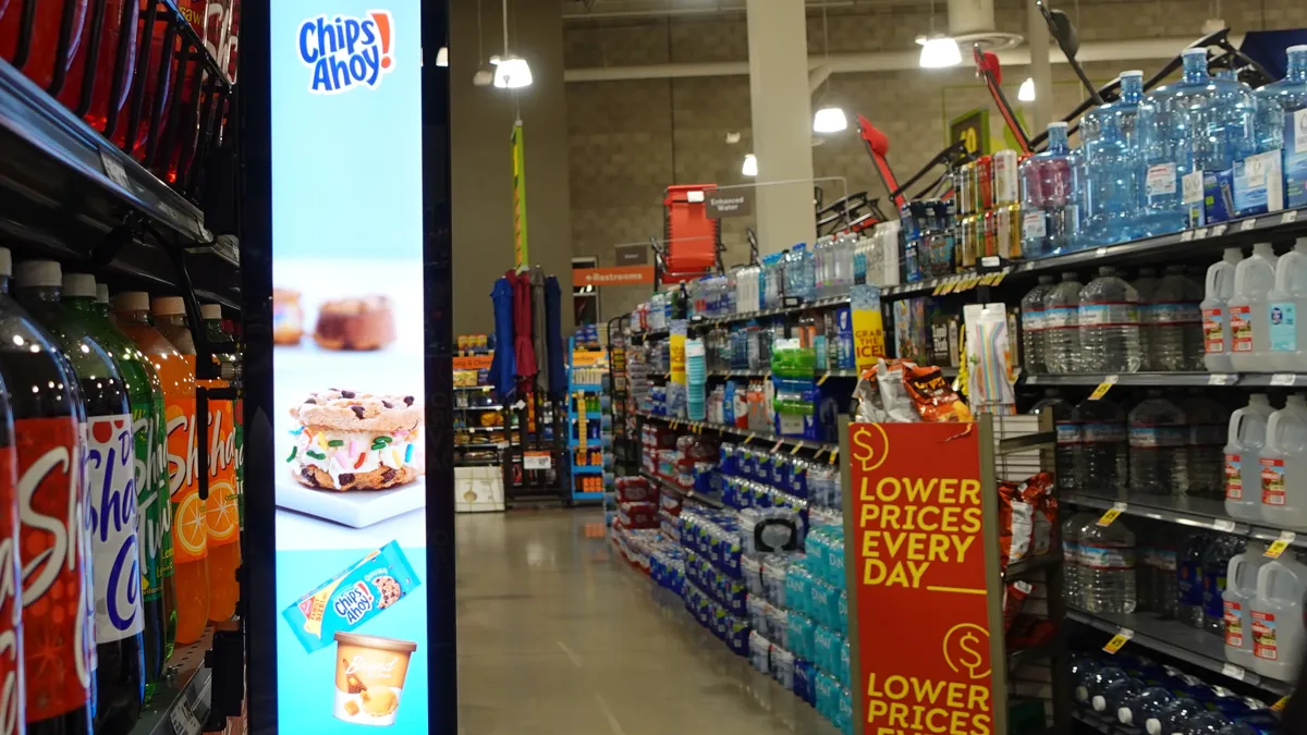 A vertical video banner in a Homeland grocery store operated by Quad