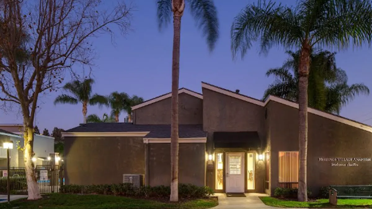 Apartments with palm tree in the foreground.