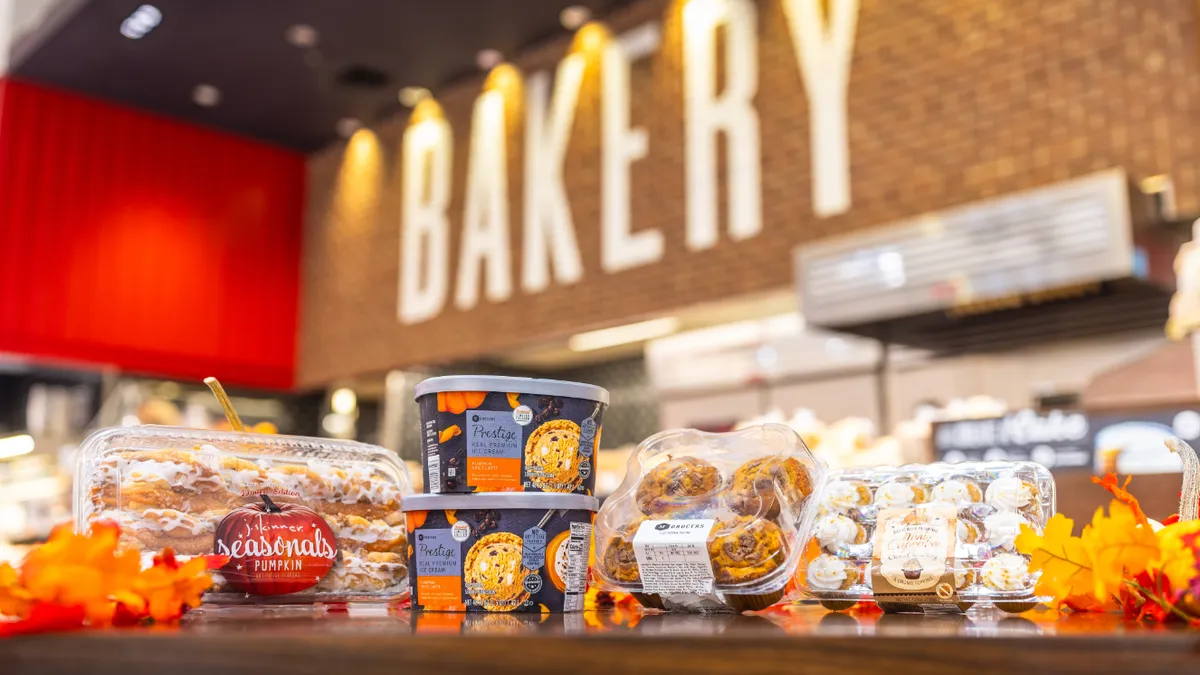 Ice cream tubs and an assortment of bakery items in front of an in-store bakery sign at a grocery store.