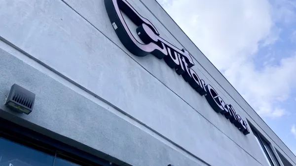 Guitar Center storefront signage at a location in Virginia Beach with a blue sky.