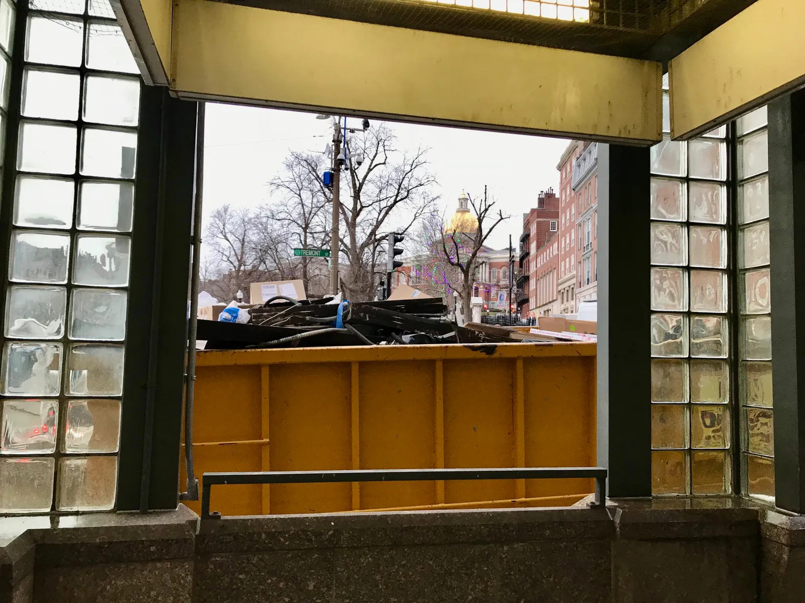 Massachusetts State House dome behind container of waste