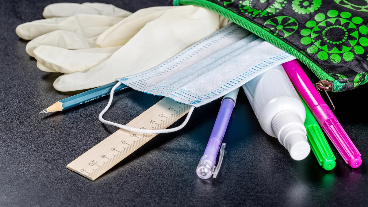 Open pencil case with school supplies and personal protection items. Study during quarantine