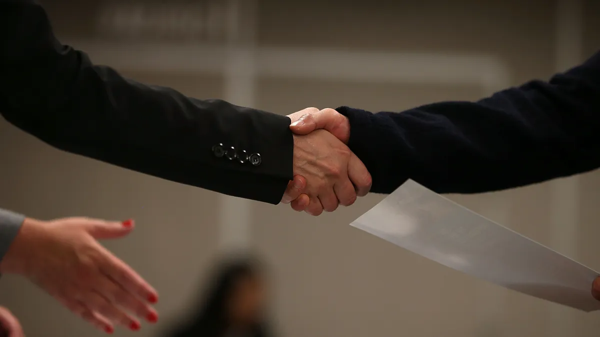 A close up of two people shaking hands.