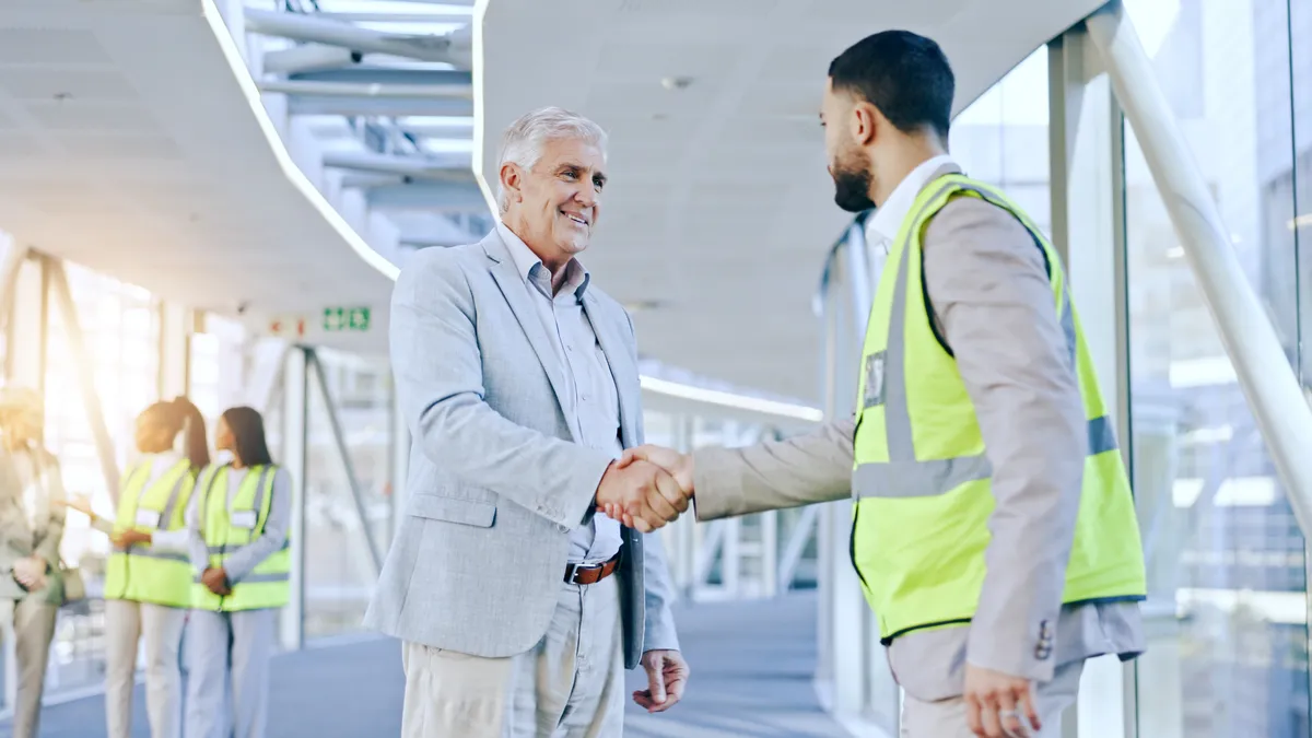 A businessman shakes hand with a contractor.