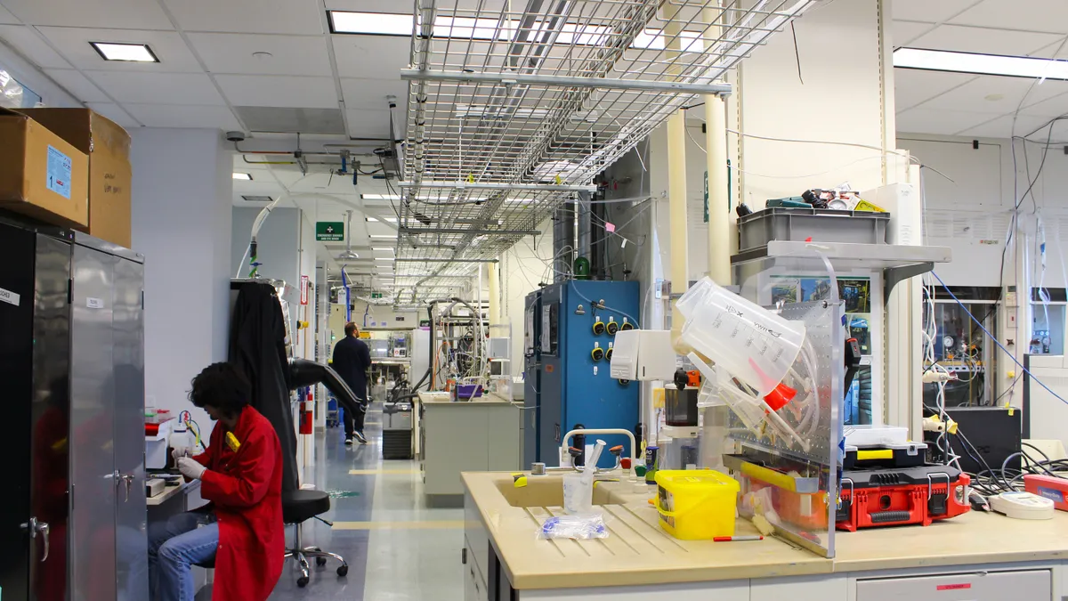 Two researchers in lab coats working in a biotechnology laboratory.