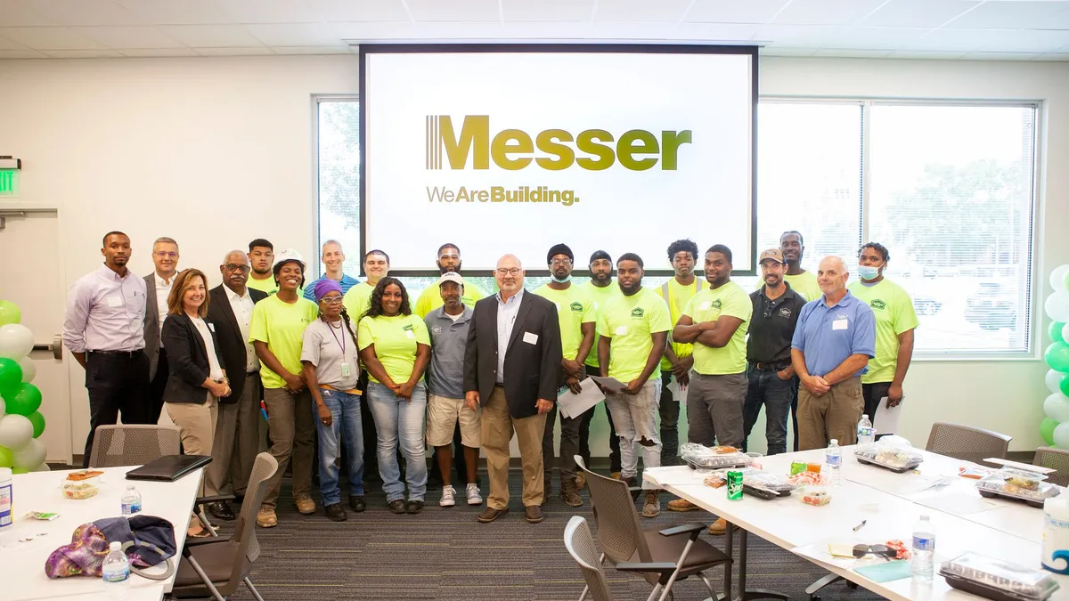 Several construction workers and executives stand for a group photo.