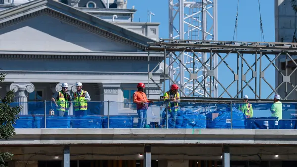 A group of construction workers on top of a building.