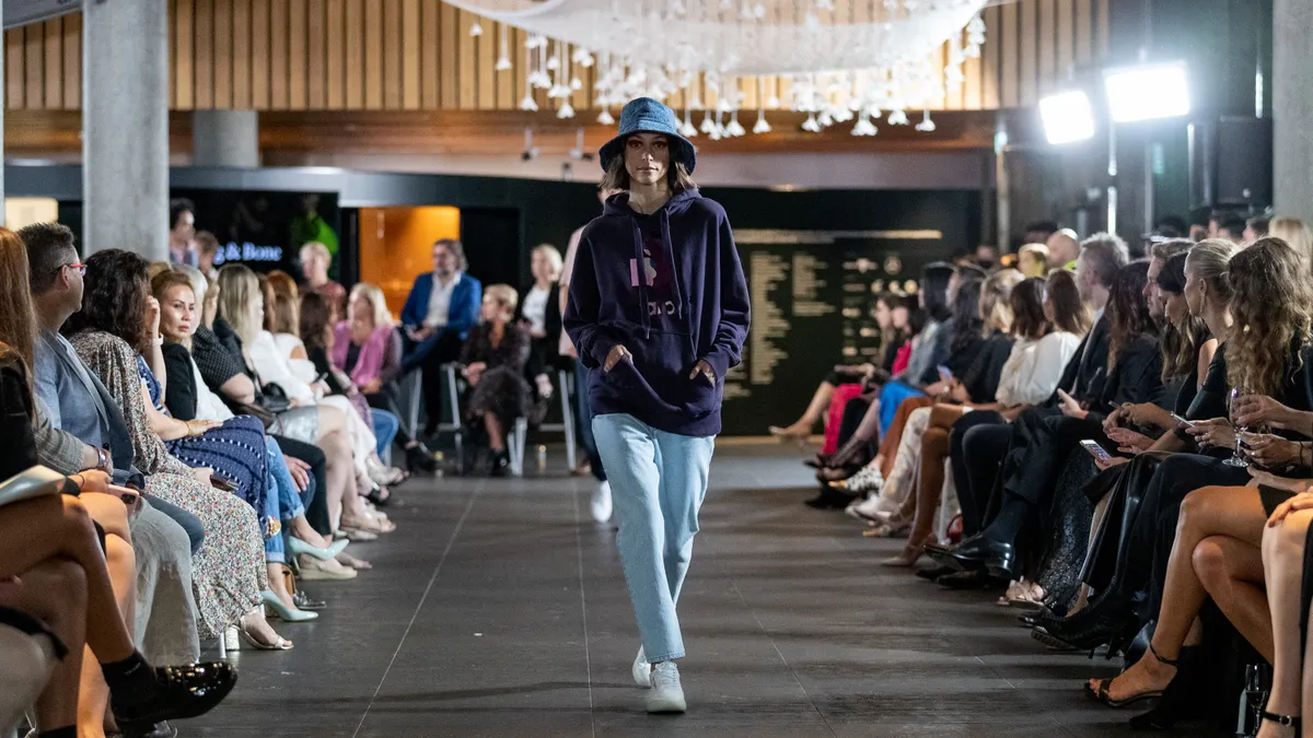 A model walks the runway wearing rag & bone, as people watch from both sides.