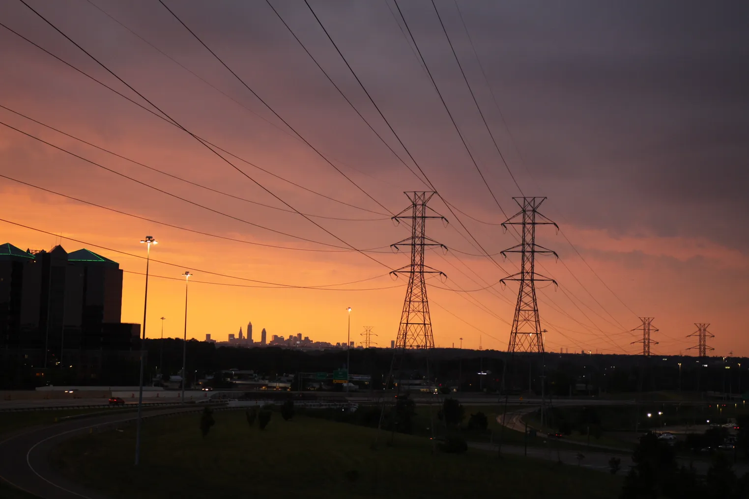 Power lines leading into the city of Cleveland Ohio at sunset time.