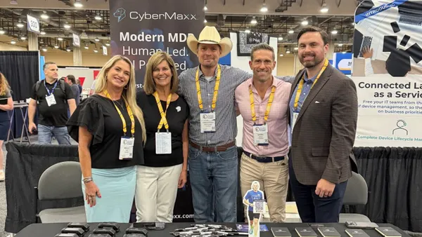 five people standing at a booth named CyberMaxx