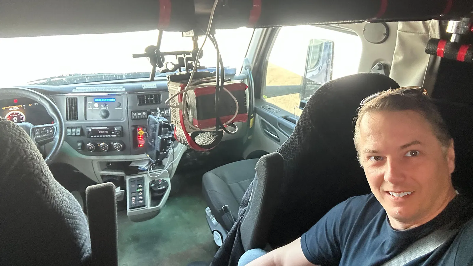 Chris Urmson sits in the backseat of a heavy-duty truck during Aurora's first driverless commercial haul on public roads on May 1, while a camera records the drive.