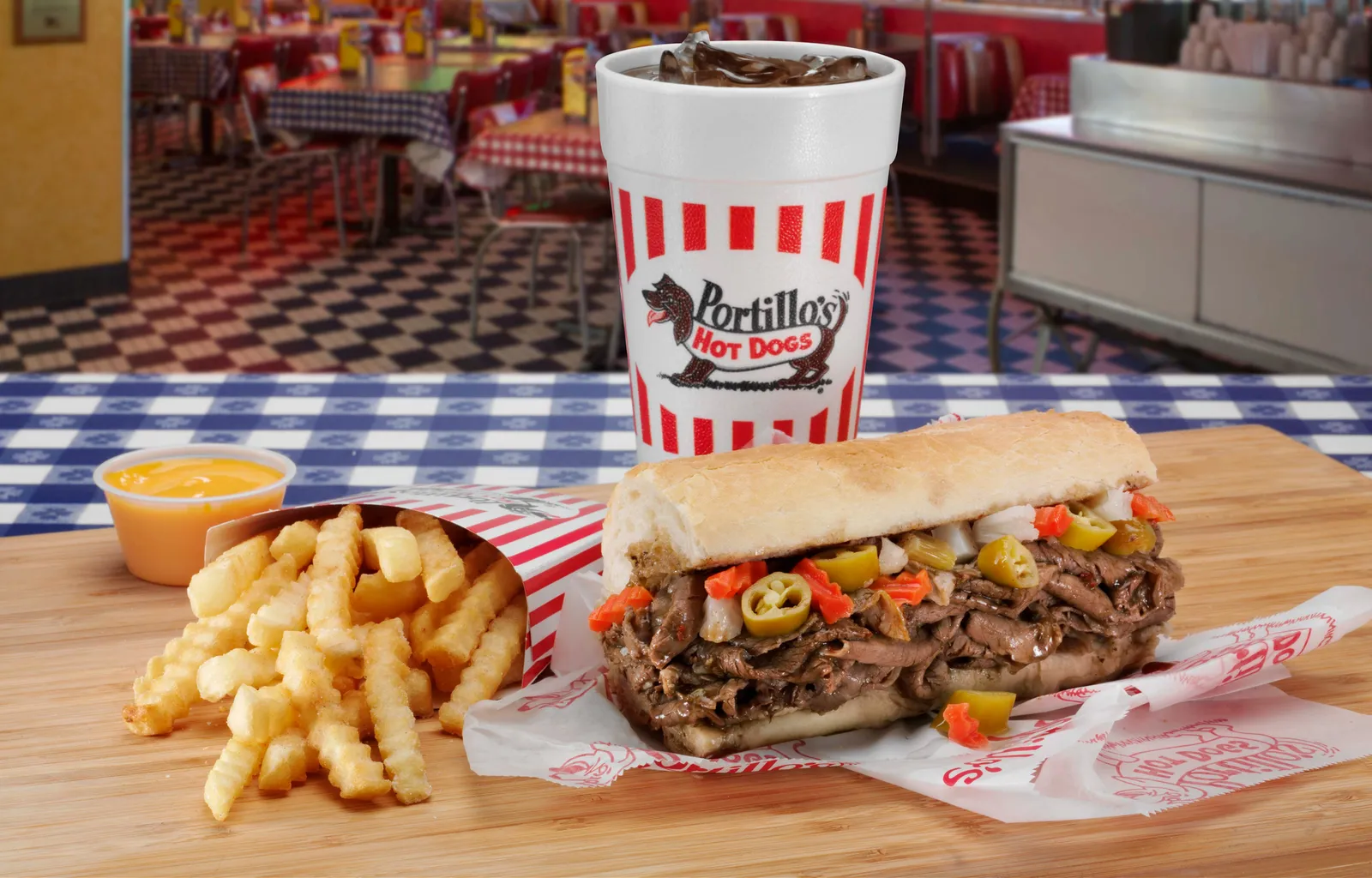 An image of a beef sandwich, fries and a drink with Portillo's branding on it