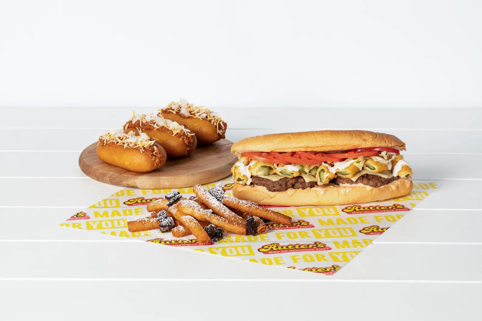 A photo of Oreo funnel cake fries, chili cheese corn dogs and fried pickles cheeseburger sub on a wrapper with the words &quot;Made for you&quot; and &quot;Rutter&#x27;s&quot; on it repeatedly.