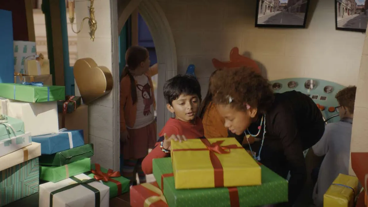 Children stacking a pile of wrapped presents