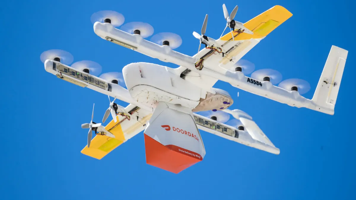 A Wing drone used by DoorDash delivers a Wendy's package.