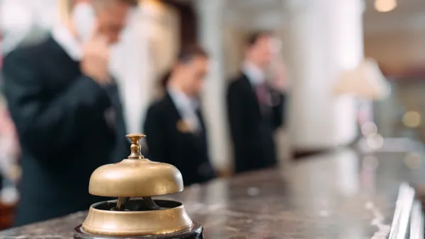 An image of a hotel front desk with staff blurred in background