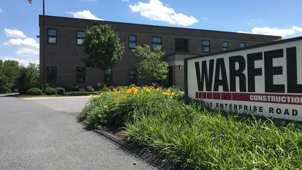 An image of a sign and an office building.