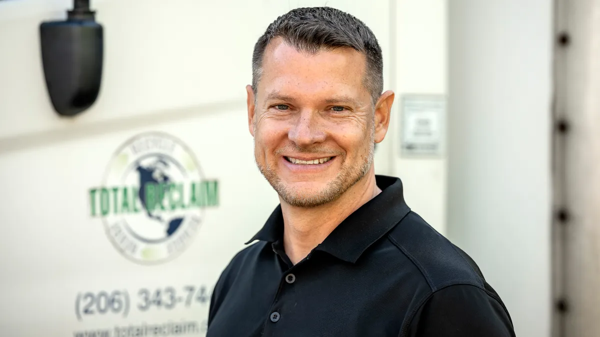 Man in polo shirt standing in front of truck